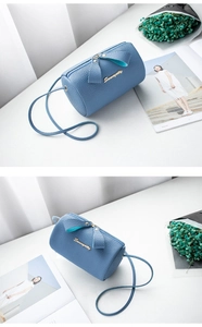 Macro shot of light blue lychee pattern leather crossbody bag with golden logo