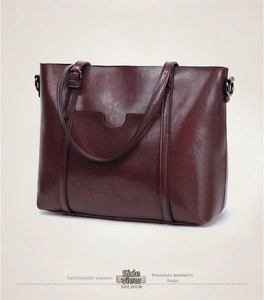 Vue latérale d'un grand sac cabas bordeaux vintage en similicuir brillant