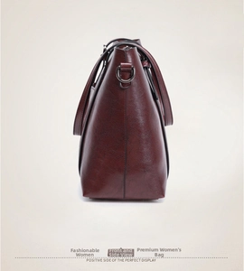 Vue latérale du sac fourre-tout bordeaux avec boucles argentées et bandoulière réglable