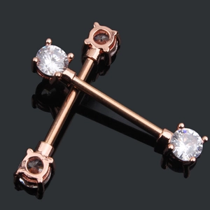 Close-up of rose gold nipple rings with sparkling round zircon in a cross layout