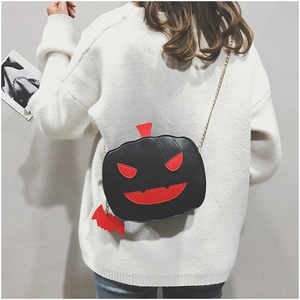 Detail of pumpkin shaped Halloween crossbody bag with bat charm and gold chain strap