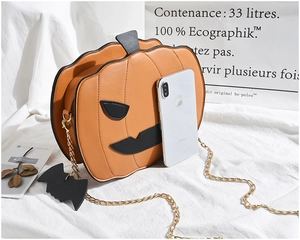 Detail of pumpkin-shaped Halloween bag with orange leather texture and metal chain
