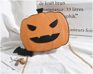 Detail of pumpkin crossbody bag with gold chain strap and black bat charm decoration