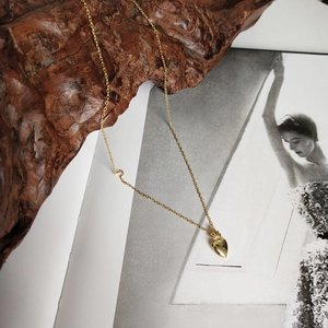 Detailed view of a 3D golden heart pendant necklace on a lifestyle background
