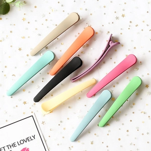 Flat lay of colorful matte banana hair clips on starry paper background showing rich variety