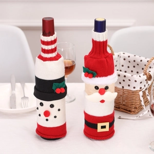 Detail of knitted Santa and Snowman wine bottle covers on a festive Christmas table