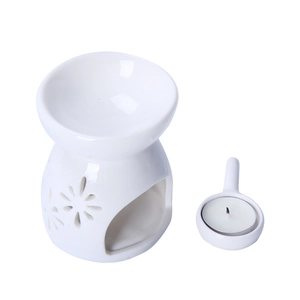 White floral cutout ceramic essential oil burner with matching handle candle holder