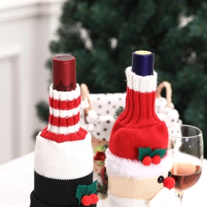 Close-up of knitted Christmas wine bottle covers with Santa Claus and festive stripe motifs