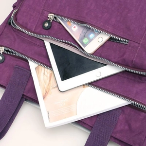 Purple nylon shoulder bag with multiple zippered pockets and spacious compartments