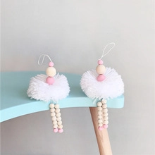 Detail of handmade boho ballet fairy charms with pink wooden beads and white plush pompoms