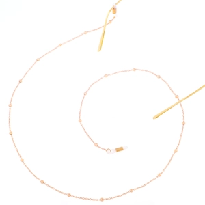 Detailed view of rose gold glasses chain with small beads and clear anti-slip rubber loops