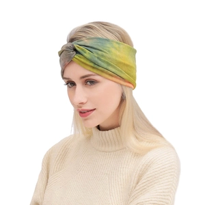Detail of bohemian tie-dye elastic headband with a cross-knot twist design on the front