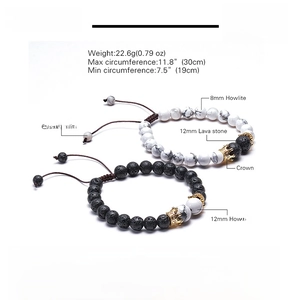 Detail view of 8mm lava and howlite stone bracelets with a golden crown charm