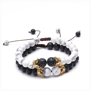Detailed close-up of 8mm lava rock and white turquoise bracelets with gold crown charms