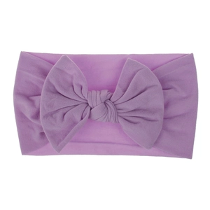 Dettaglio della fascia per neonati color lavanda con un grande fiocco in nylon fatto a mano