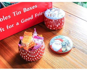 Detailed view of round Christmas tin boxes with festive Santa and reindeer illustrations