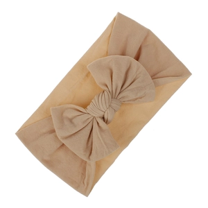 Fascia per neonati in nylon morbido con grande fiocco beige su fondo bianco