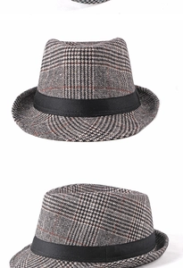 Detail of classic houndstooth fedora hat with black satin ribbon and texture close-up