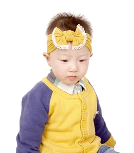 Soft nylon baby headband featuring a yellow lace bow detail shown on an infant model