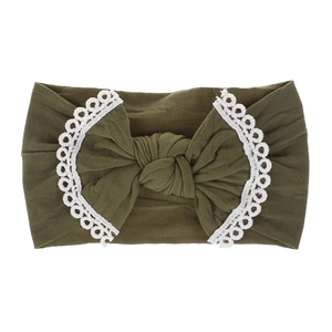 Detail of olive green nylon headband with soft lace edges and central knot for babies
