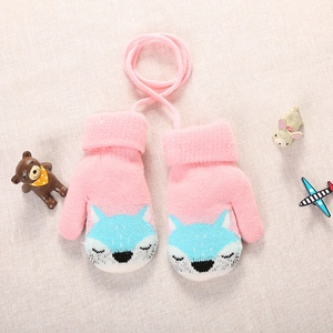 Detail of pink knitted toddler mittens with blue fox pattern and neck string
