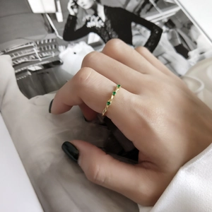 Minimalist gold plated 925 silver ring featuring three round green gemstones on finger