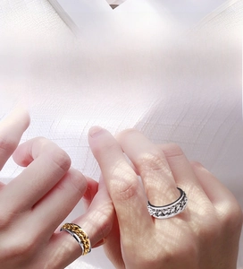 Macro detail of rotating stainless steel chain rings in silver and gold-tone finish