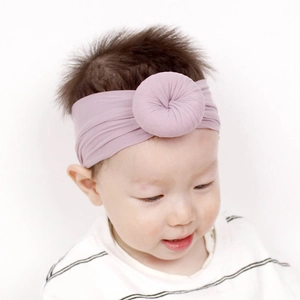 Dettaglio fascia neonato in nylon con design a ciambella pieghettata in rosa antico