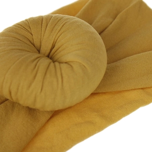 Dettaglio della fascia in nylon giallo senape con un design a nodo rotondo morbido