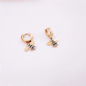 Détail macro de boucles d'oreilles abeille dorées avec cristaux noirs et brillants