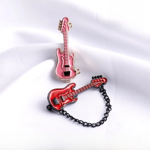 Macro detail of mini electric guitar enamel pins with musical theme on white fabric