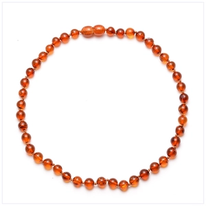 Macro detail of natural Baltic amber round beads necklace with deep cognac hues