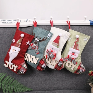 Détail de chaussettes de Noël avec appliques Père Noël et renne sur tissu en lin