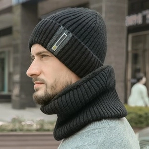 Vue de profil d'un homme portant un bonnet d'hiver en tricot noir et cache-cou assorti