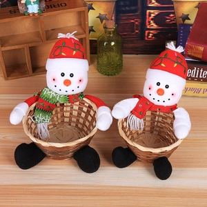Close-up of snowman plush Christmas candy baskets on a wooden table for holiday decor