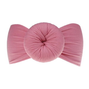 Dettaglio della fascia elastica in nylon rosa con un grande nodo morbido a ciambella