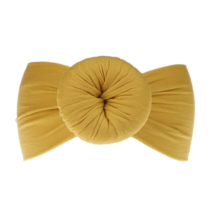 Dettaglio fascia per neonati in nylon giallo senape con fiocco a nodo a ciambella