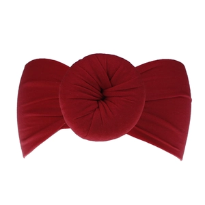 Dettaglio della fascia per neonati in nylon rosso scuro con un nodo morbido a ciambella