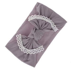Detail of soft purple baby headband with delicate white lace trim and bow knot