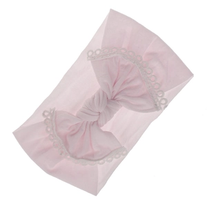 Soft pink nylon baby headband featuring a large bow with white lace trim detail.