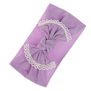 Detail of purple baby headband with soft lace trim and large knit cotton bow decoration