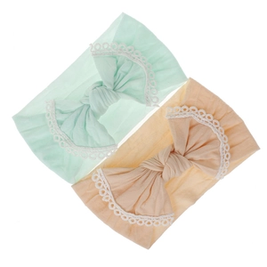 Detailed view of two soft nylon baby headbands with lace bows in mint and peach colors.