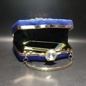 Blue glitter evening clutch with gold metal handle and large diamond clasp showing interior