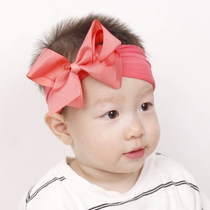 Detailansicht eines Babys mit einem weichen korallenrosa Haarband mit großer Schleife
