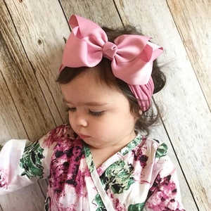 Detailansicht eines Babys mit einem großen rosa Schleifen-Stirnband aus elastischem Nylon