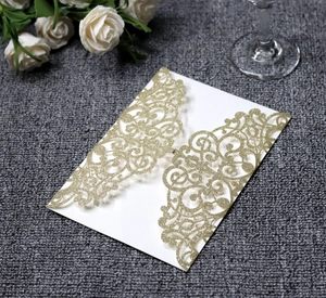 Macro detail of laser-cut gold glitter wedding invitation with floral hollow design