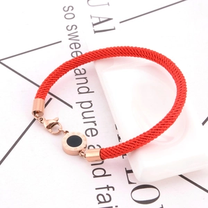 Détail du bracelet en cordon tressé rouge avec fermoir rose doré et chiffre romain