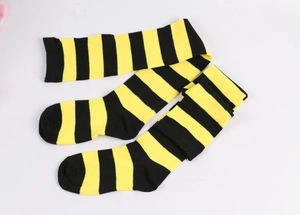Flat lay of yellow and black striped over-knee socks in high-quality cotton blend fabric