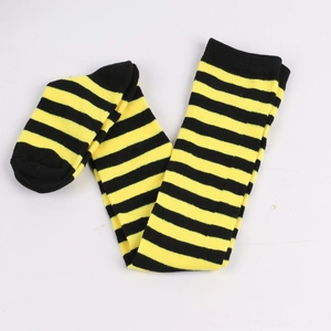 Flat lay of black and yellow striped over-knee socks in soft knitted fabric texture