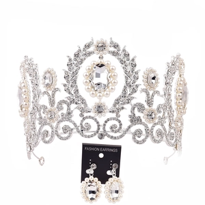 Detail of silver bridal tiara and earrings set with rhinestones and elegant pearls